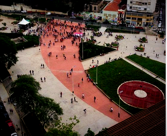Vista aérea da praça em uso, com o percurso vermelho e o disco central