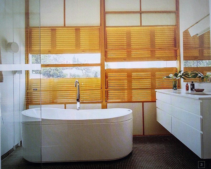 Sala de banho da suíte com banheira e venezianas amarelas