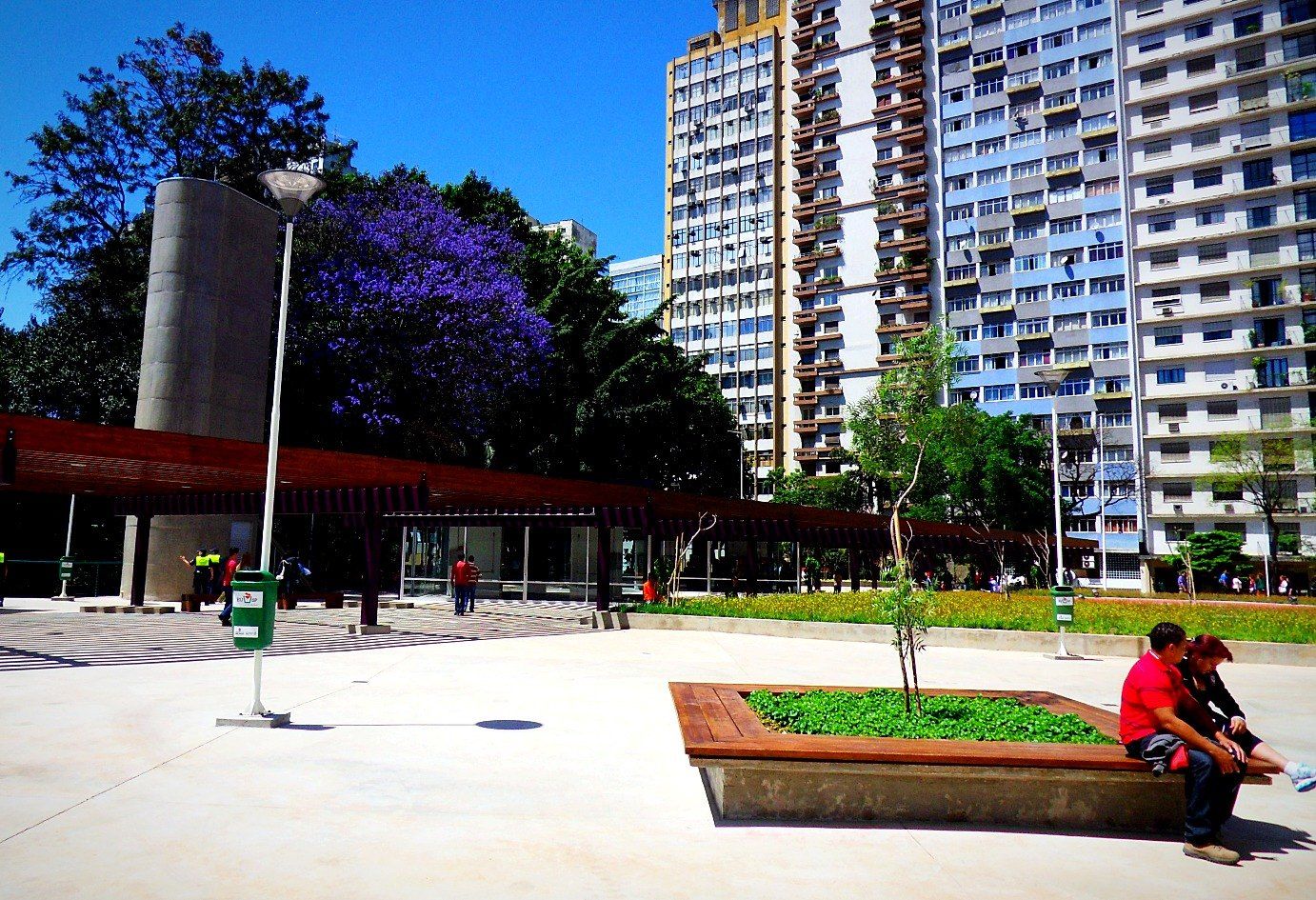 Esplanada com floreira-banco, torre de ventilação e pergolado ao fundo