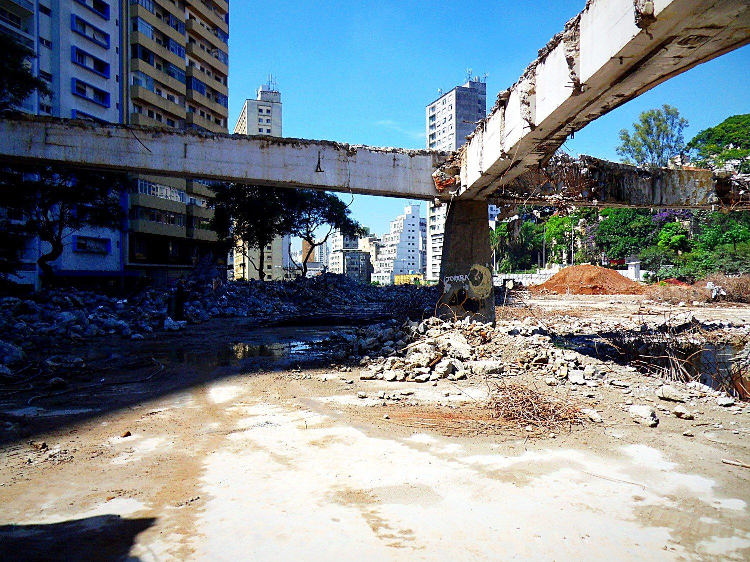 Vigas remanescentes da antiga estrutura em meio à demolição
